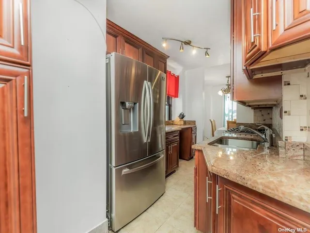 a kitchen with stainless steel appliances granite countertop a refrigerator and a sink