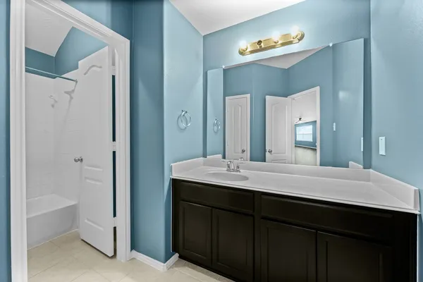 a bathroom with a double vanity sink mirror and bathtub