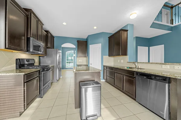 a large kitchen with stainless steel appliances granite countertop a stove and a sink