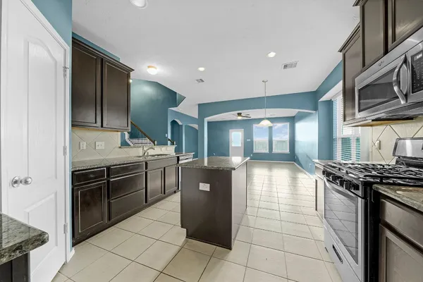 a kitchen with stainless steel appliances granite countertop a stove and a refrigerator