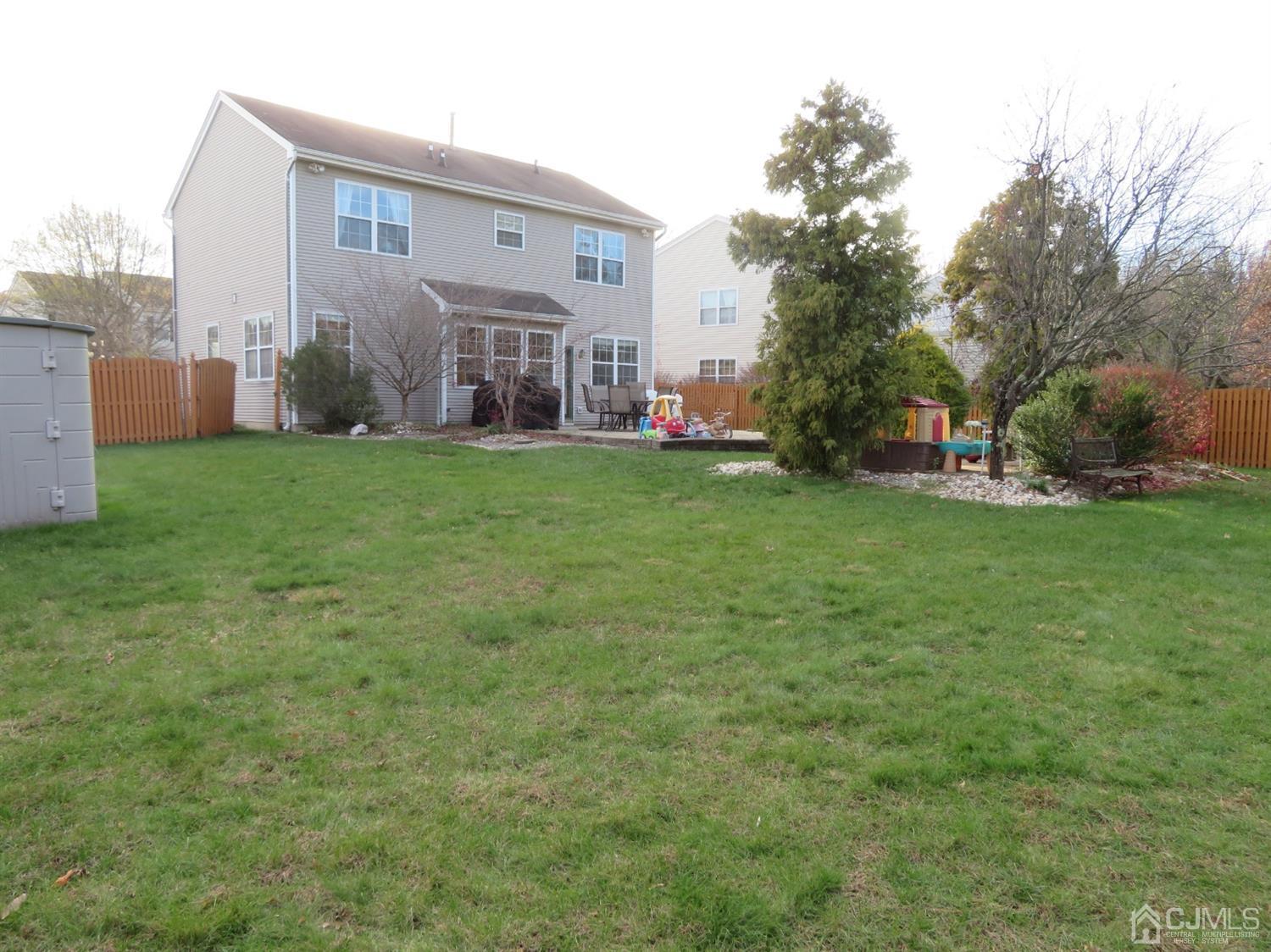55 Devon Drive East Brunswick, NJ 08816 - Photo 21 of 28 a view of a backyard with plants and a large tree