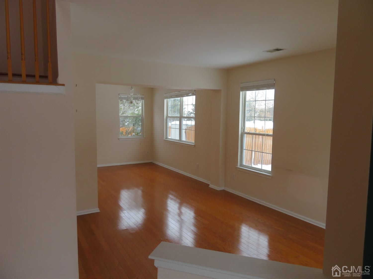 55 Devon Drive East Brunswick, NJ 08816 - Photo 3 of 28 a view of an empty room with wooden floor and a window