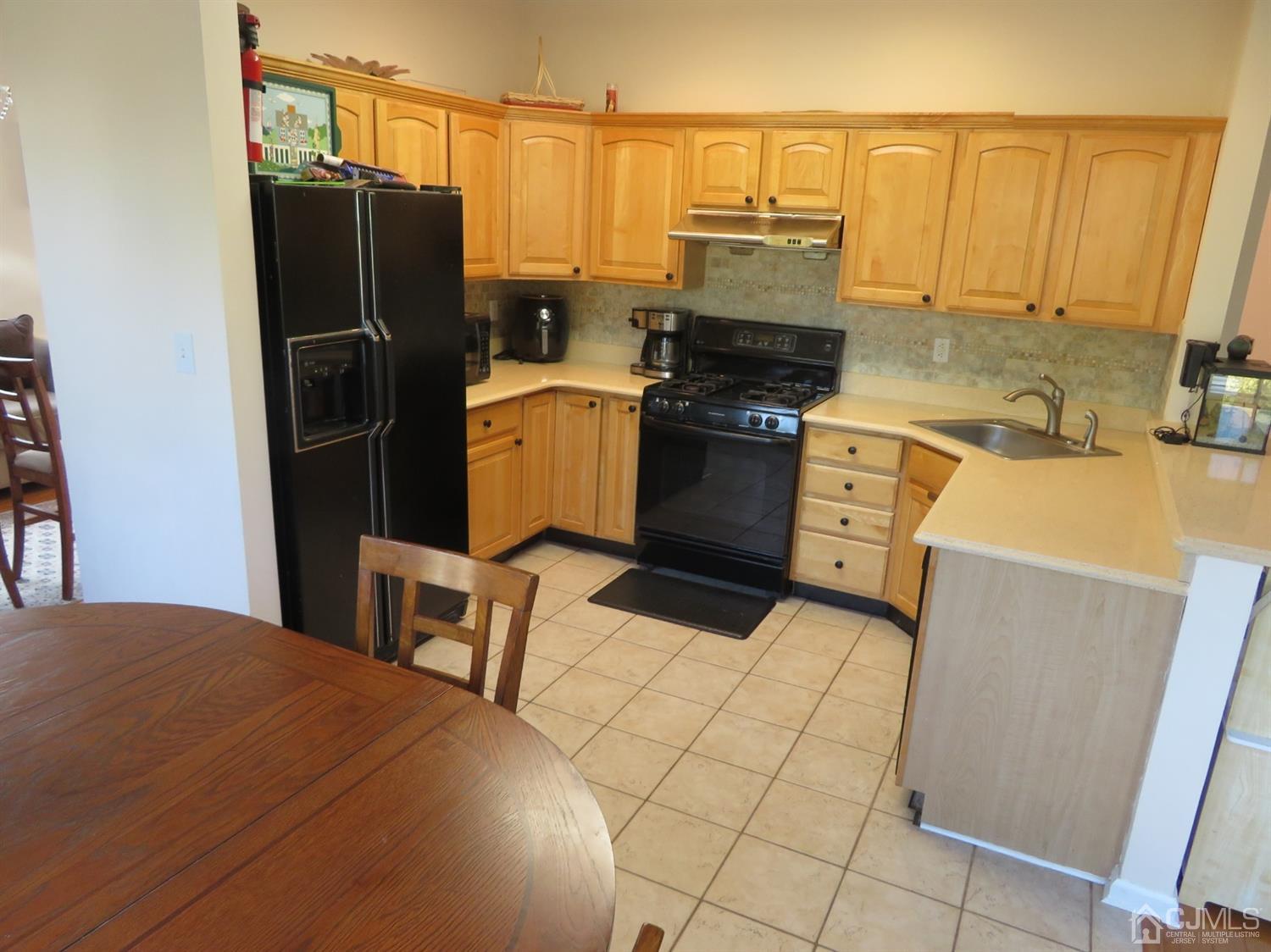 55 Devon Drive East Brunswick, NJ 08816 - Photo 5 of 28 a kitchen with a refrigerator a stove top oven and cabinets