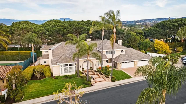 a view of a house with a yard and palm trees