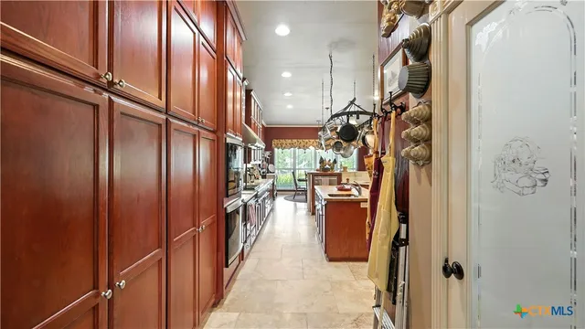 a view of a patio with table and chairs and floor to ceiling window and plants