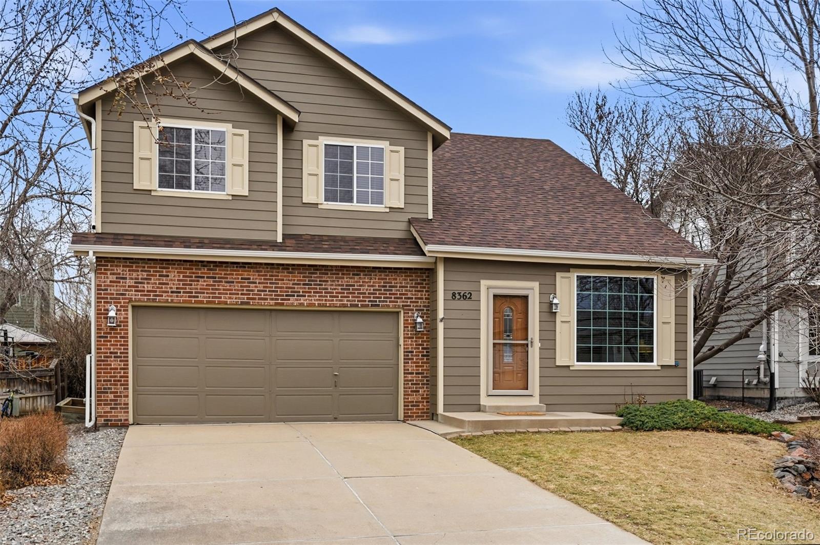 8362 Sunnyside Place Highlands Ranch, CO 80126 - Photo 1 of 50 a front view of a house with a yard and garage