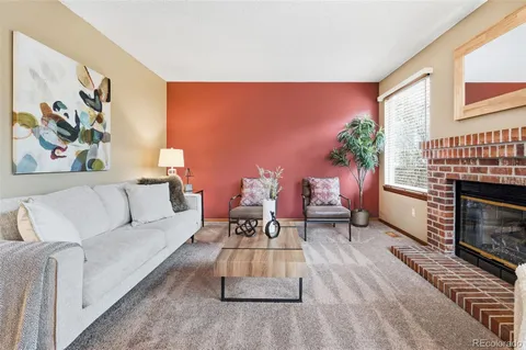 a living room with furniture a fireplace and a large window