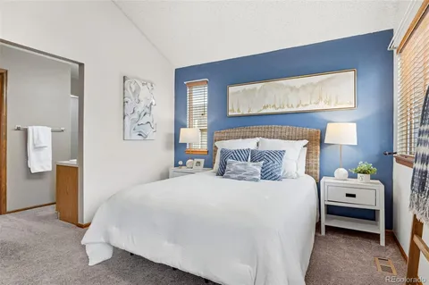 a bedroom with bed and large windows