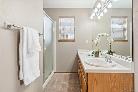 a spacious en suite bathroom with a double sink and a mirror