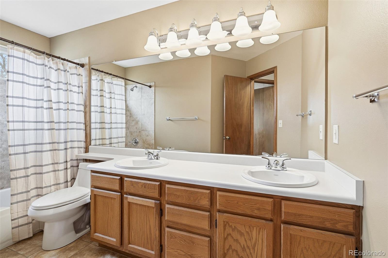 8362 Sunnyside Place Highlands Ranch, CO 80126 - Photo 37 of 50 a bathroom with a double vanity sink mirror and toilet