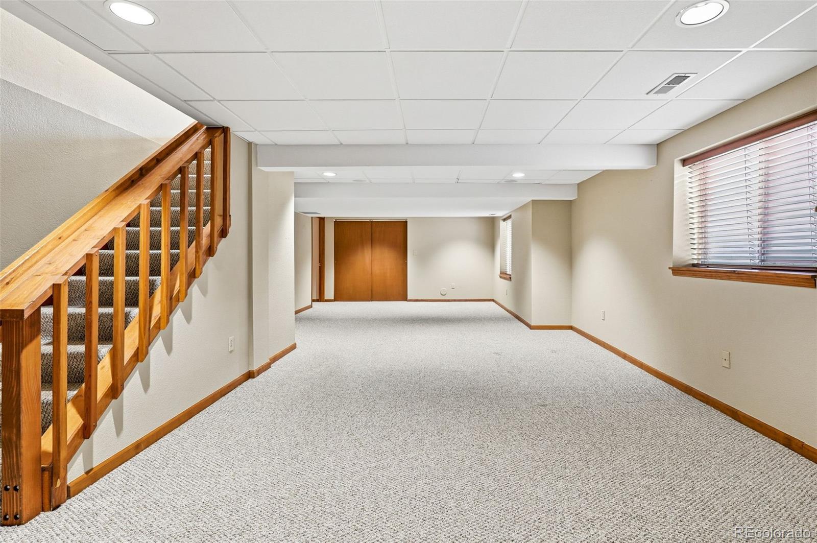 8362 Sunnyside Place Highlands Ranch, CO 80126 - Photo 40 of 50 a view of an empty room with wooden floor and stairs