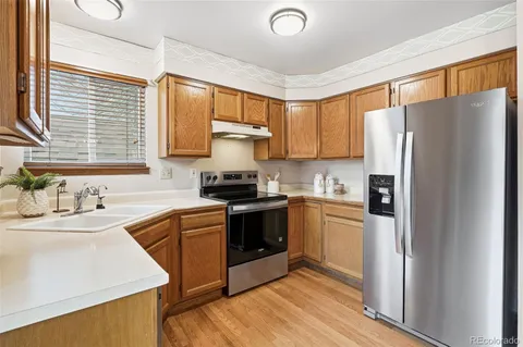a kitchen with a refrigerator sink and cabinets