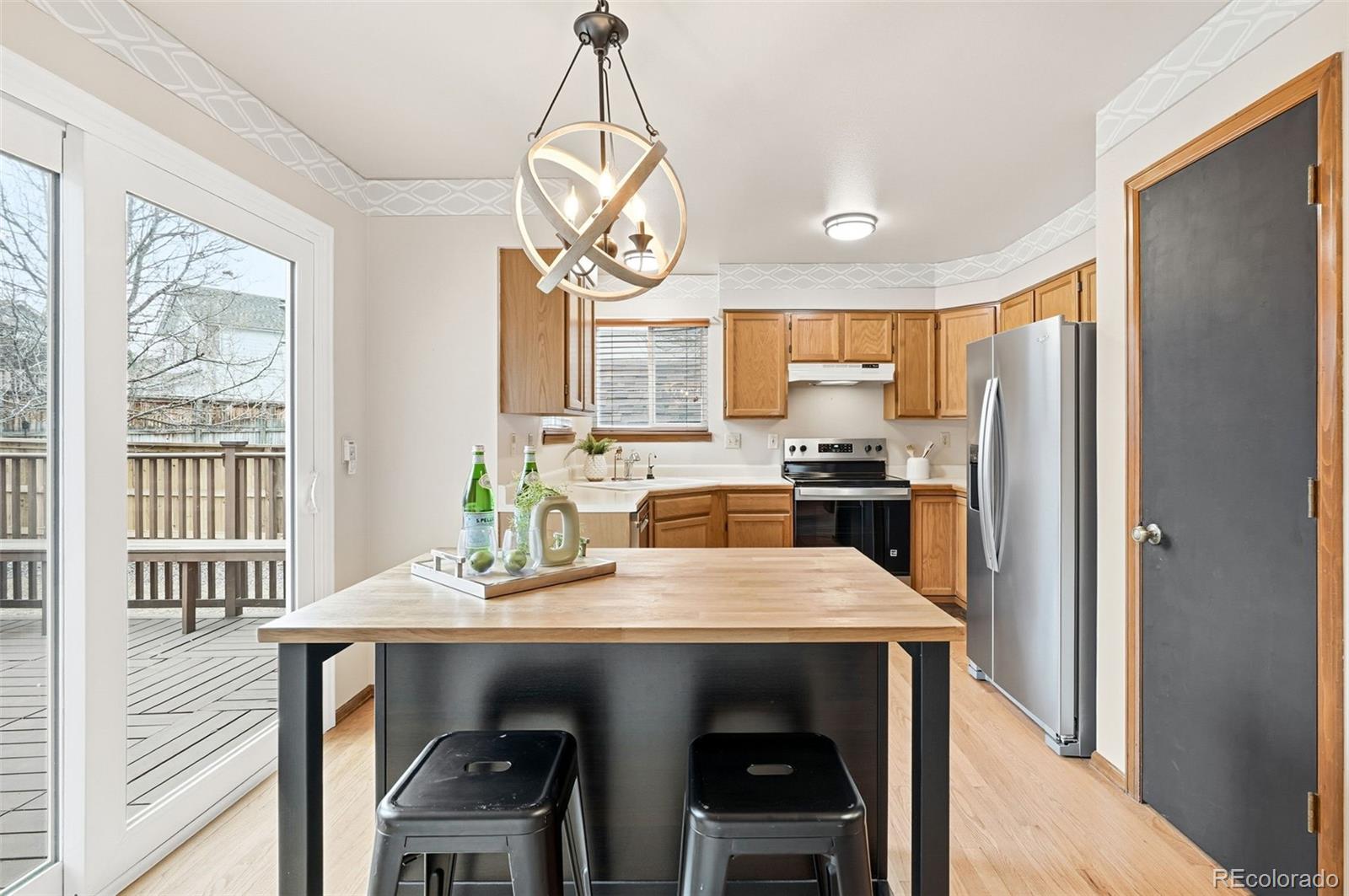 8362 Sunnyside Place Highlands Ranch, CO 80126 - Photo 6 of 50 a kitchen with stainless steel appliances a table chairs and refrigerator