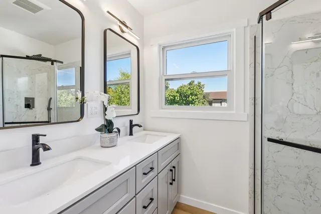 a bathroom with a double vanity sink and a mirror