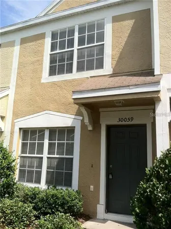 a front view of a building with a plants and a window