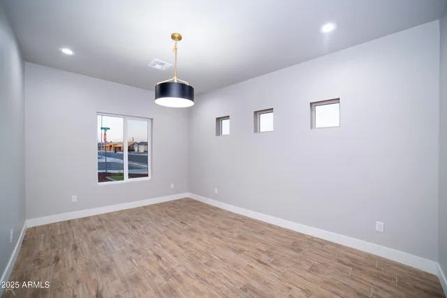 an empty room with wooden floor and entrance