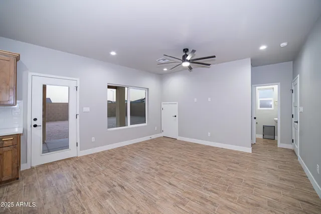 a large kitchen with stainless steel appliances a large counter top a stove a sink dishwasher a microwave oven and a stove with wooden floor