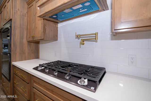 a kitchen with stainless steel appliances granite countertop a sink a stove and a wooden floors