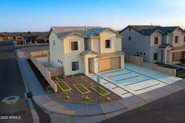 a view of a white house with table chairs and wooden floor