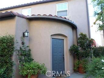 a house with a small yard plants and large tree