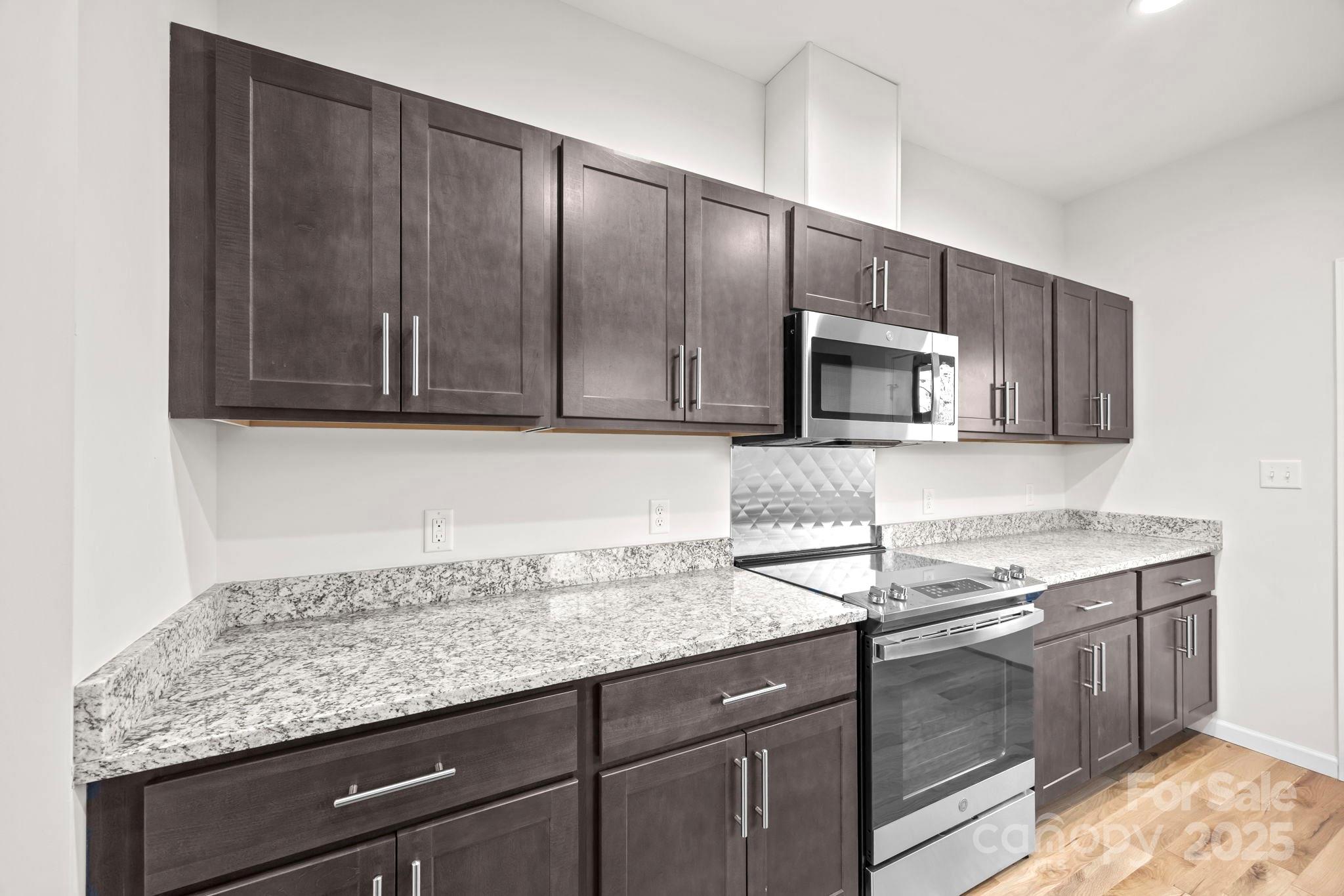 7 Berry Crest Lane Arden, NC 28704 - Photo 23 of 41 a kitchen with granite countertop wood cabinets stainless steel appliances and a sink