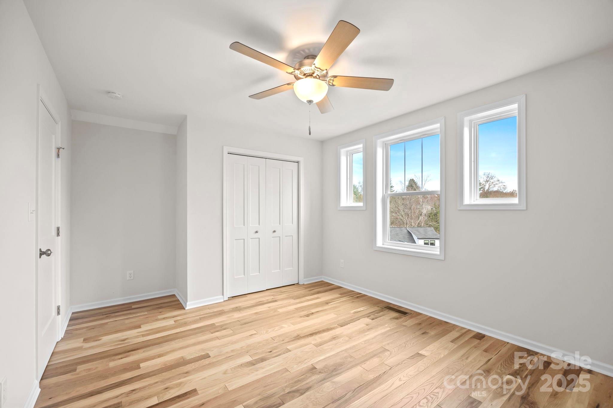 7 Berry Crest Lane Arden, NC 28704 - Photo 33 of 41 a view of an empty room with wooden floor and a ceiling fan