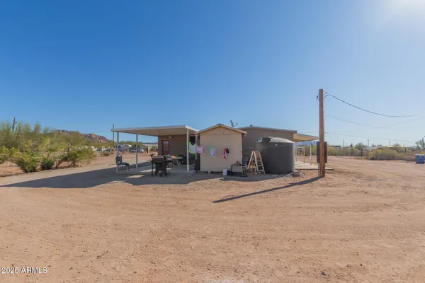 a view of a house with a yard and sitting area