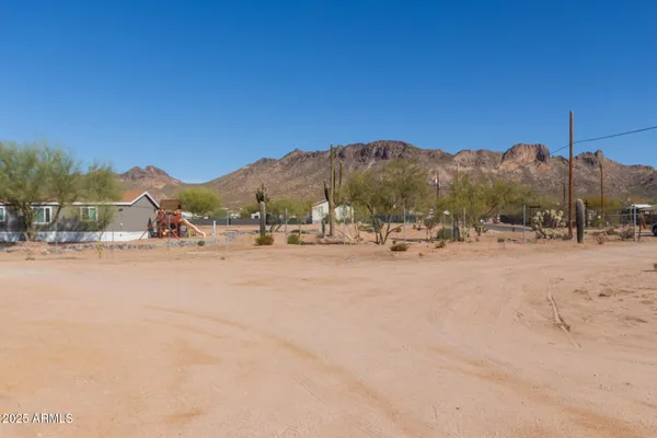 a view of dirt road with a building in the background