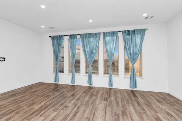 a view of kitchen with kitchen island wooden floor center island and stainless steel appliances