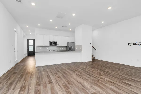 a view of kitchen with wooden floor and electronic appliances