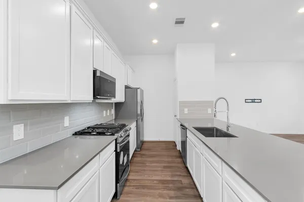 a kitchen with stainless steel appliances granite countertop a sink stove and refrigerator