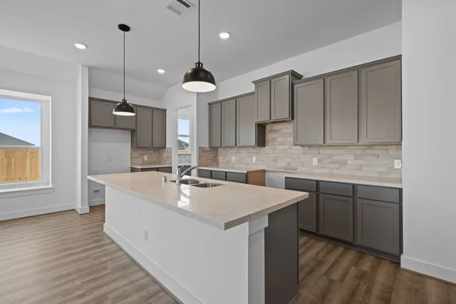 a large kitchen with kitchen island a sink stainless steel appliances and cabinets