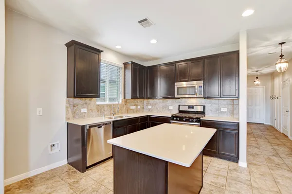 a kitchen with stainless steel appliances a sink stove and cabinets