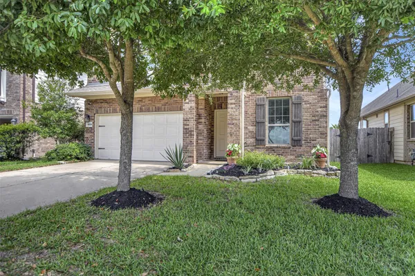 a view of a house with backyard and a tree