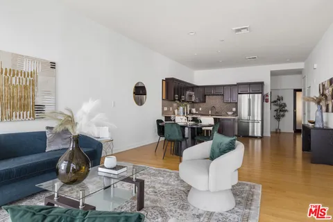 a living room with furniture a rug and gym equipment