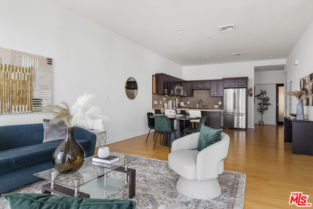801 South Grand Avenue, Unit 1508 Los Angeles, CA 90017 - Photo 13 of 56 a living room with furniture and a wooden floor
