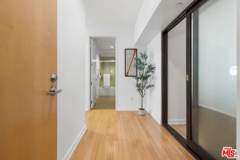 a view of a hallway with wooden floor and staircase