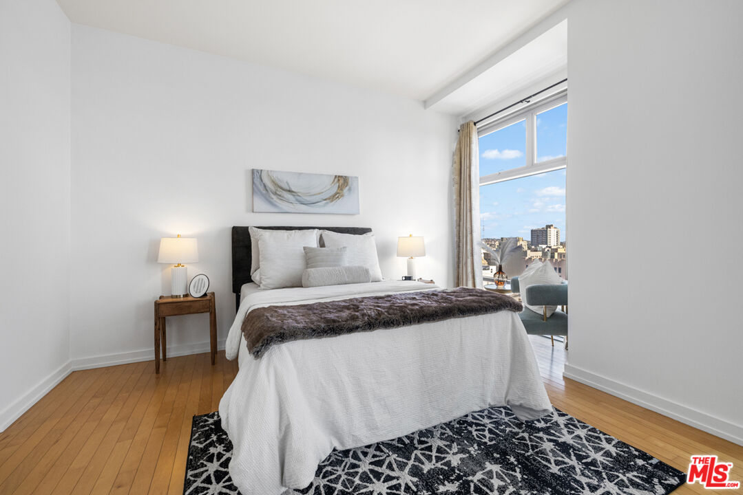 801 South Grand Avenue, Unit 1508 Los Angeles, CA 90017 - Photo 22 of 56 a bedroom with a bed and wooden floor