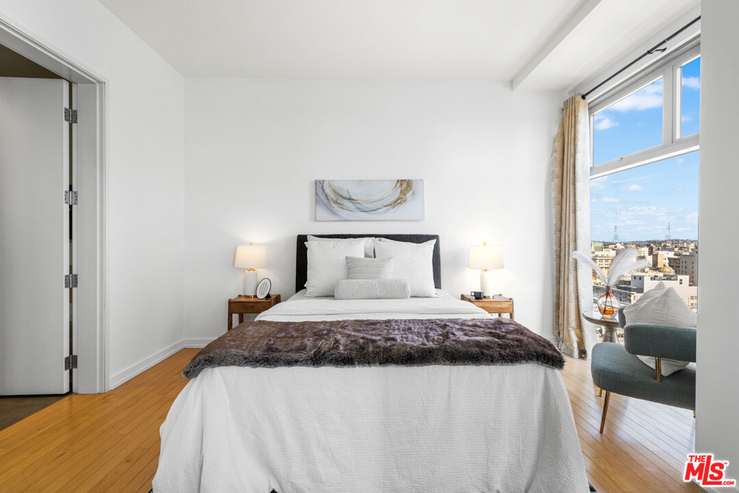 801 South Grand Avenue, Unit 1508 Los Angeles, CA 90017 - Photo 24 of 56 a bedroom with a bed and wooden floor