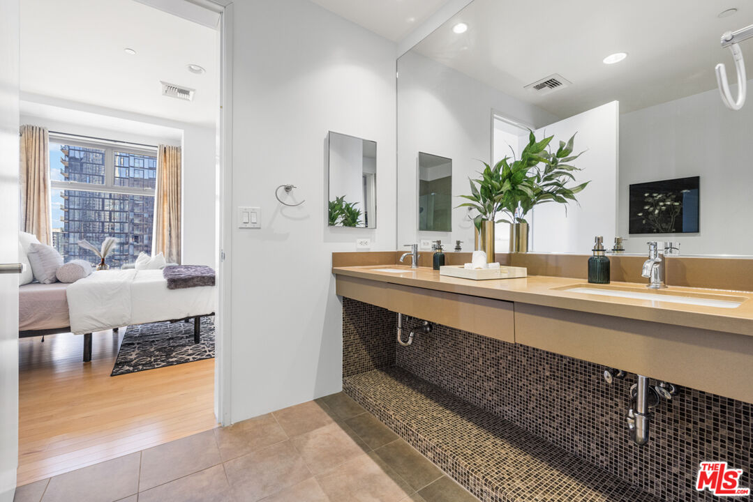 801 South Grand Avenue, Unit 1508 Los Angeles, CA 90017 - Photo 27 of 56 a bathroom with a double vanity sink and a mirror