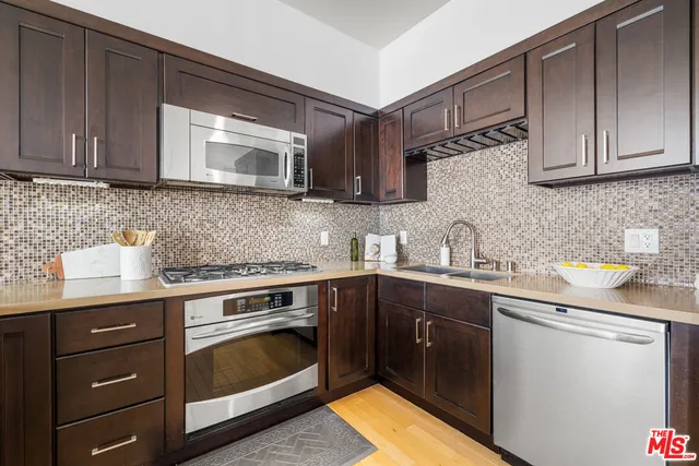 a kitchen with granite countertop a refrigerator stove and microwave