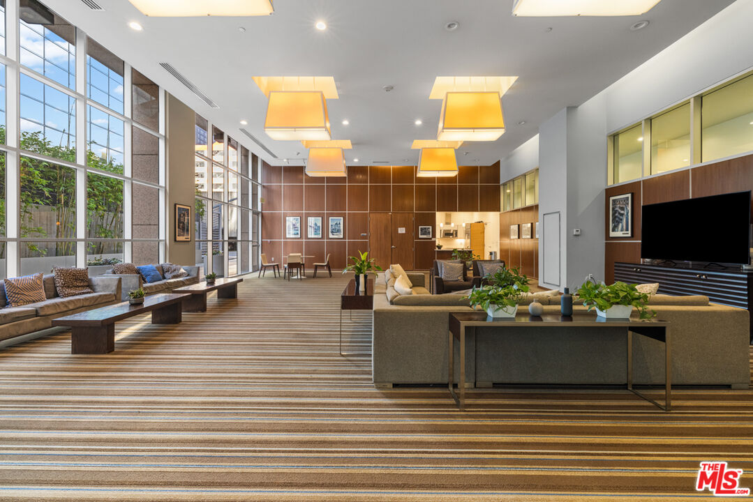 801 South Grand Avenue, Unit 1508 Los Angeles, CA 90017 - Photo 47 of 56 a living room with couches coffee table and a flat screen tv