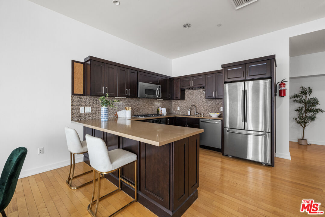 801 South Grand Avenue, Unit 1508 Los Angeles, CA 90017 - Photo 7 of 56 a kitchen with kitchen island a refrigerator a stove a sink and a oven