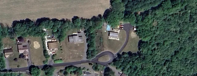 an aerial view of a house with a yard and tree s
