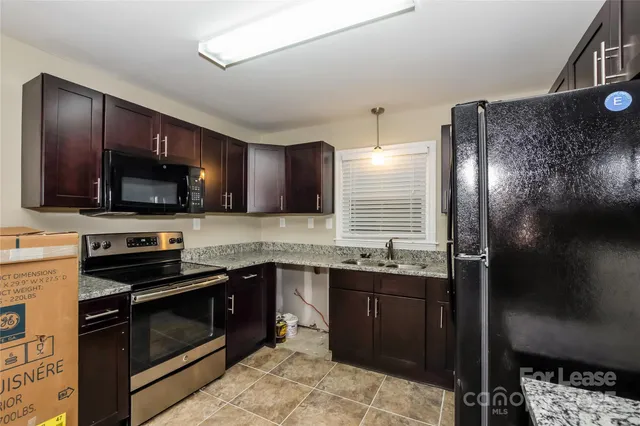 a kitchen with stainless steel appliances granite countertop a sink and stove top oven