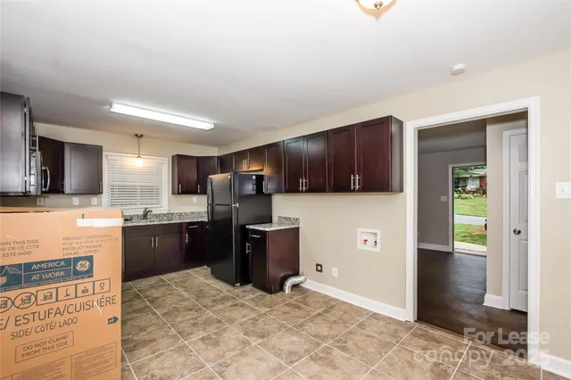 a large kitchen with stainless steel appliances kitchen island granite countertop a refrigerator stove and sink
