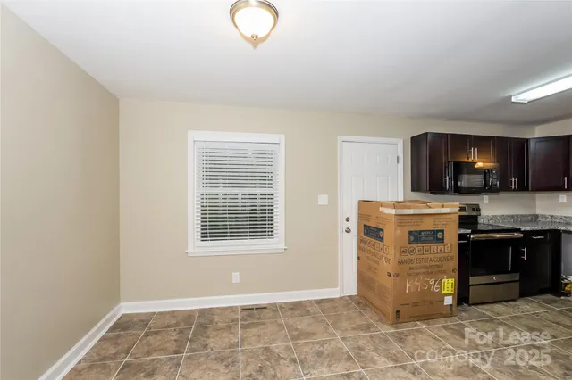 a living room with stainless steel appliances kitchen island granite countertop a stove and a sink