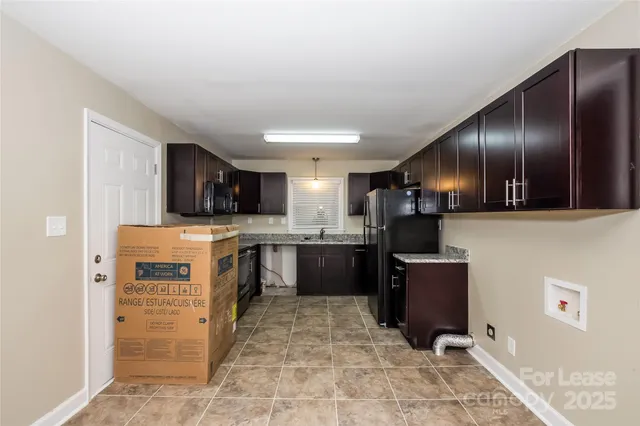a kitchen with stainless steel appliances kitchen island granite countertop a refrigerator and a stove