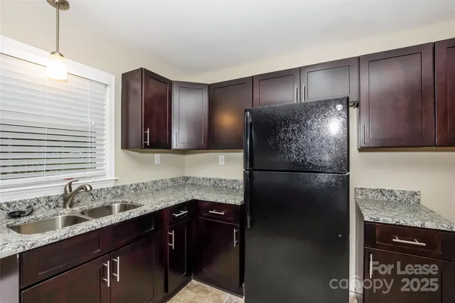 a kitchen with a sink stainless steel appliances and refrigerator
