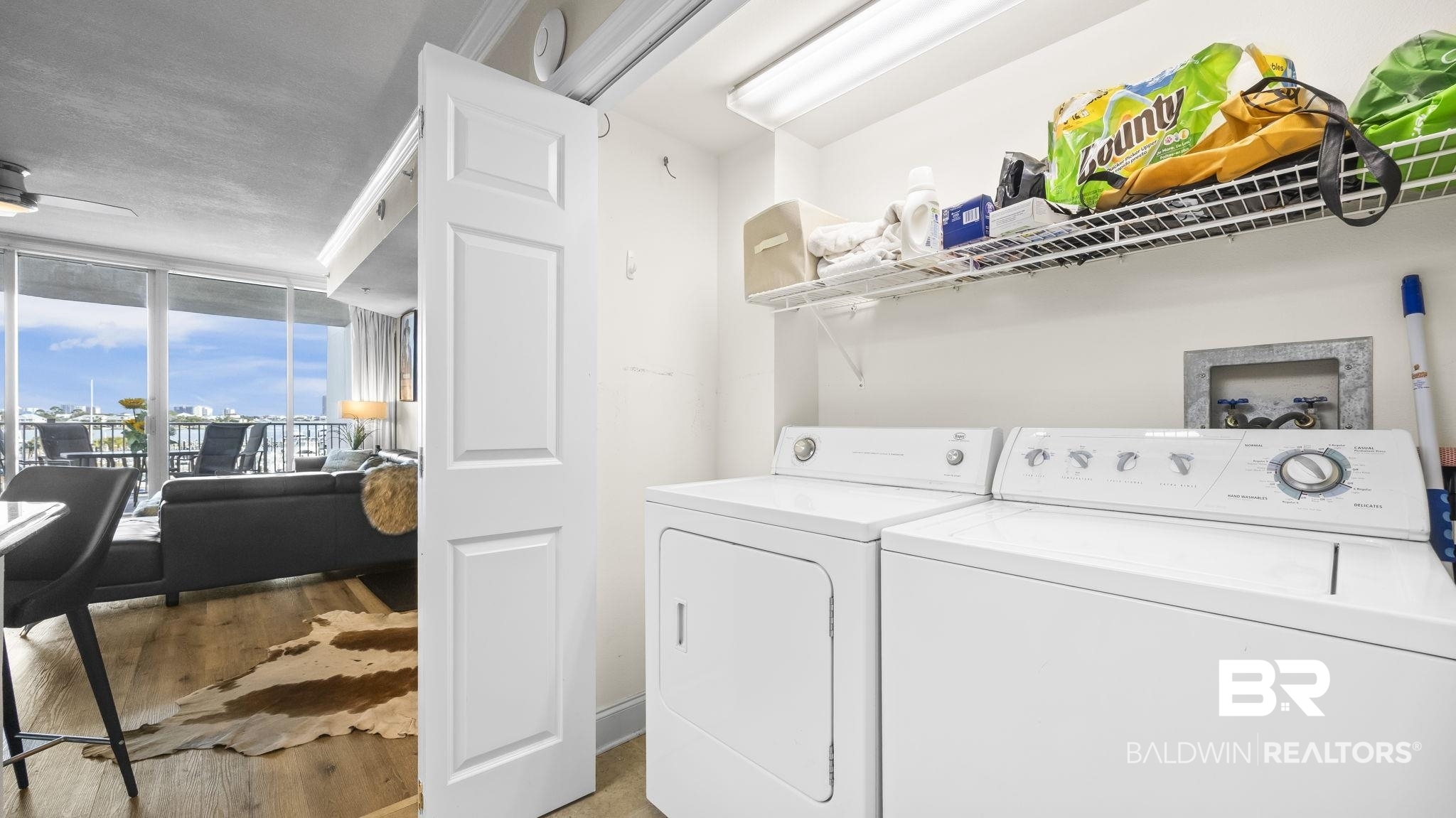 27800 Canal Road, Unit 313 Orange Beach, AL 36561 - Photo 10 of 23 Laundry area with light wood finished floors, expansive windows, washer and dryer, and ceiling fan